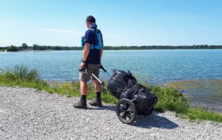 Wanderer mit Pilgerwagen am Mandichosee