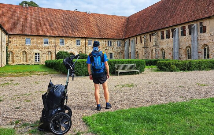 Wanderer mit Wanderanhänger vor dem Kloster Bentlage